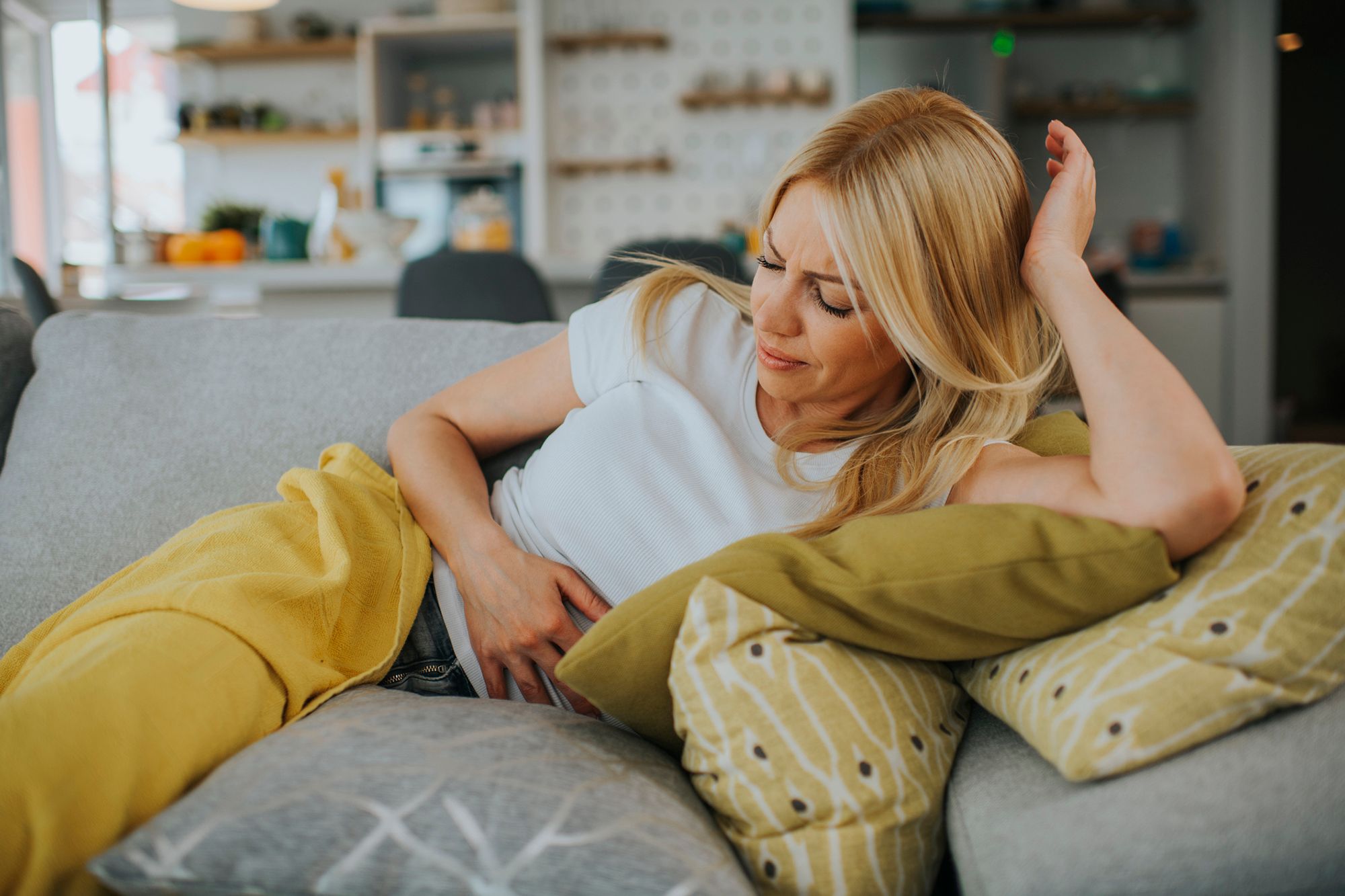 Blonde Frau liegt auf einem Sofa