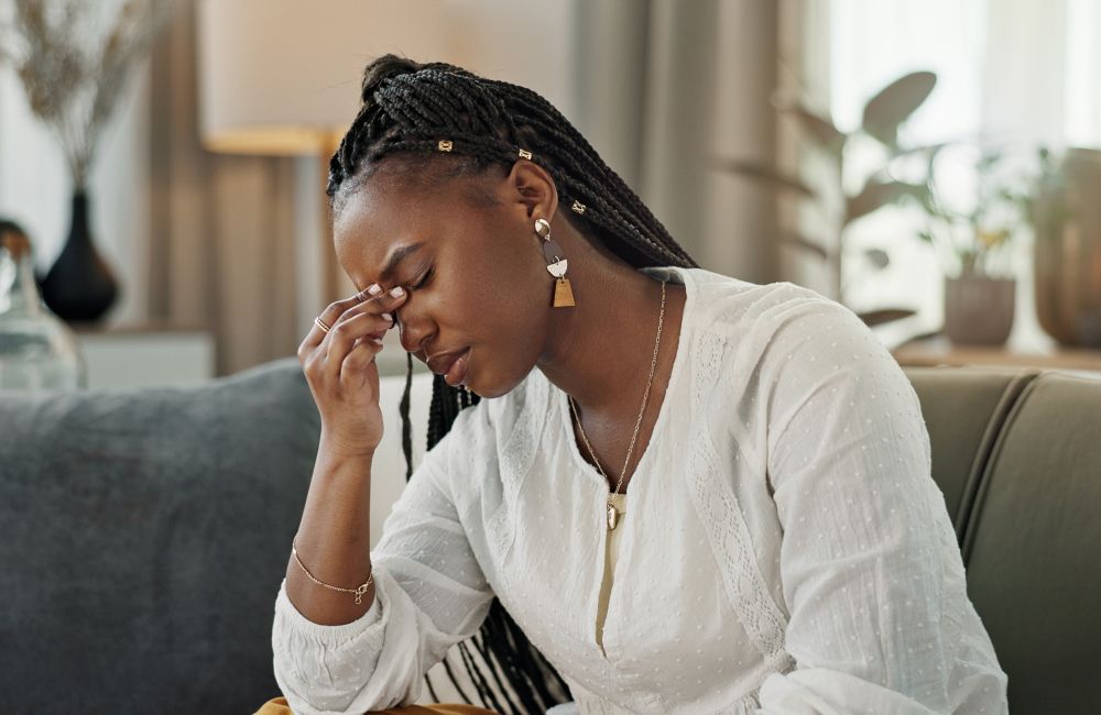 Eine Frau hält sich verzweifelt eine Hand an die Stirn