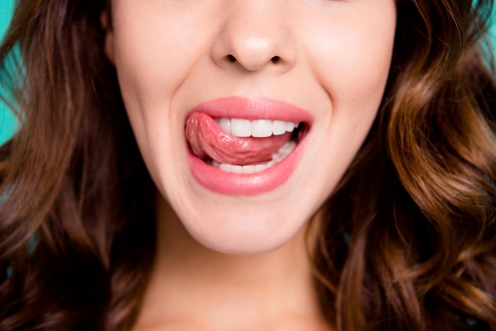 Auschschnitt aus dem Gesicht einer Frau, die sich die Lippen leckt