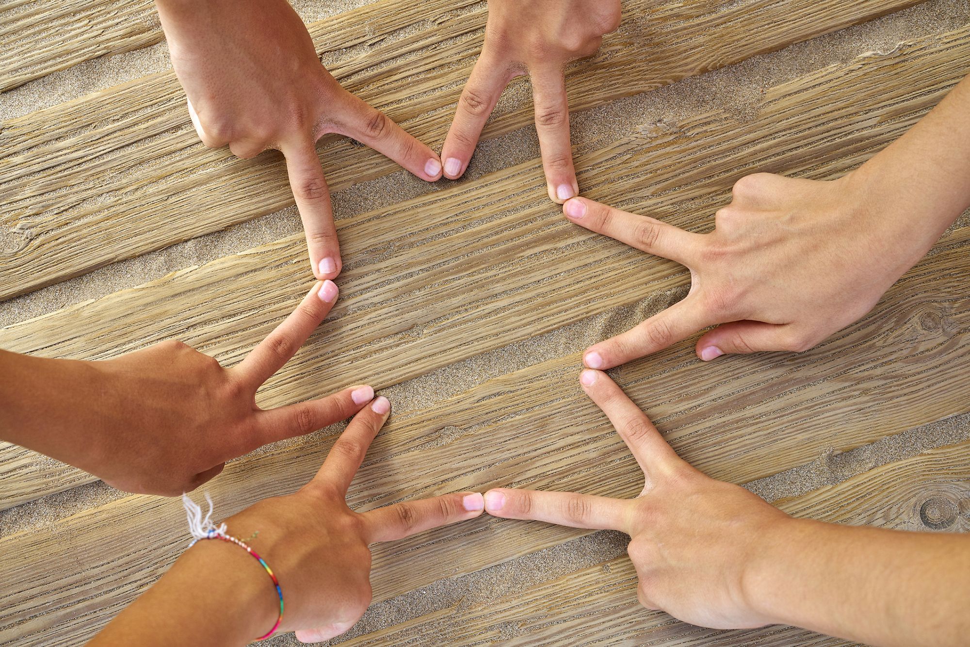 3 Menschen bilden einen Stern aus ihren Fingern