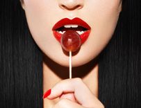 Frau mit roten Lippen und Lolli vom Gesicht