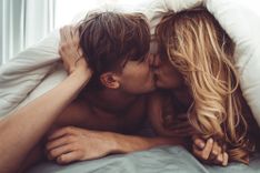 Pärchen küsst sich unter der Bettdecke